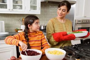 A girl and her mother cook a holiday meal together.