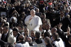 教皇弗朗西斯（Francis）在2013年在罗马的圣彼得广场（St. Peter's Square）就职期间驾驶人群。“width=