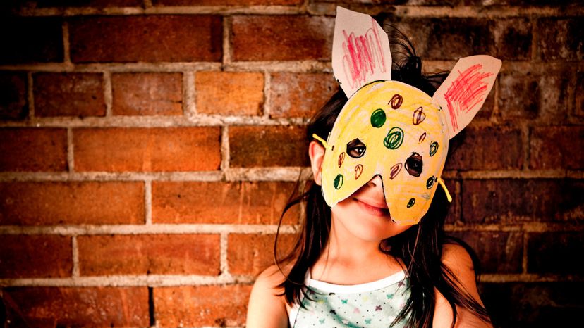 A kid with a playful paper mask