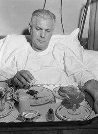 A cardiac patient looks somewhat skeptically at his tray of low-sodium food, circa 1955.