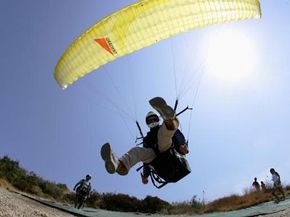 Skydiving Image Gallery A professional paragliding instructor takes off at the Kathisma beach on Lefkada Island, Greece. See pictures of skydiving.