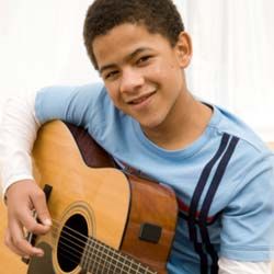 Preteen boy playing guitar