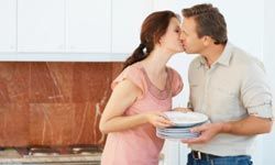 couple kissing over dishes