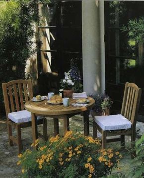 The simple teak furnishings suit the patio's small scaleand harmonize with the soft gray shades.