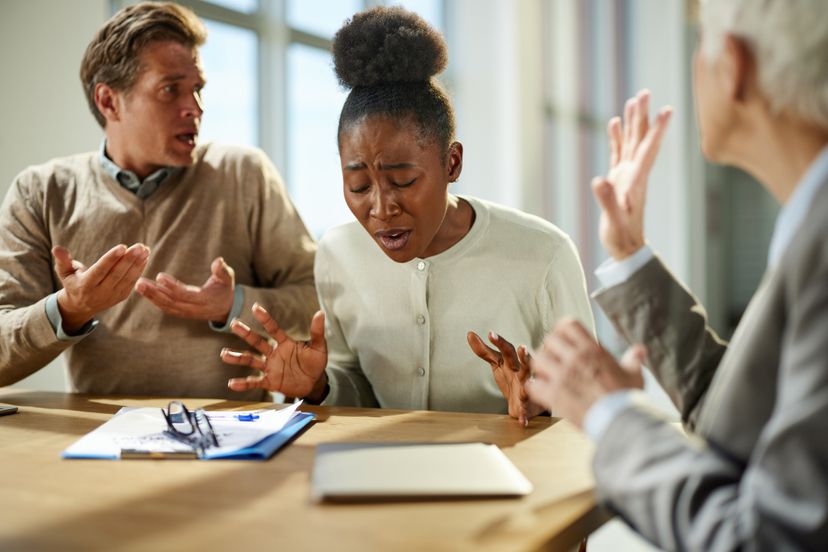 Frustrated couple arguing during a meeting with their insurance agent in the office.