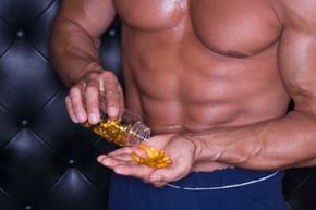 Muscular man pouring pills into hand