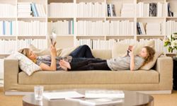 Woman and daughter lounging on couch. 