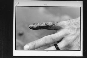 A man displays his bloodied finger after dipping his hand in the piranha-infested waters of the Parapeti River.