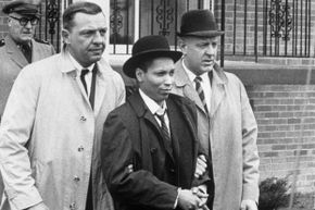 Kitty Genovese's killer, Winston Moseley, is led away in handcuffs on March 21, 1968, after escaping police custody while serving a life sentence for her death.