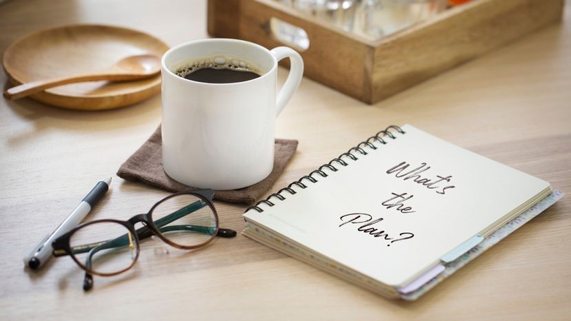 Notebook coffee cup on top of the table for planning days to travel.