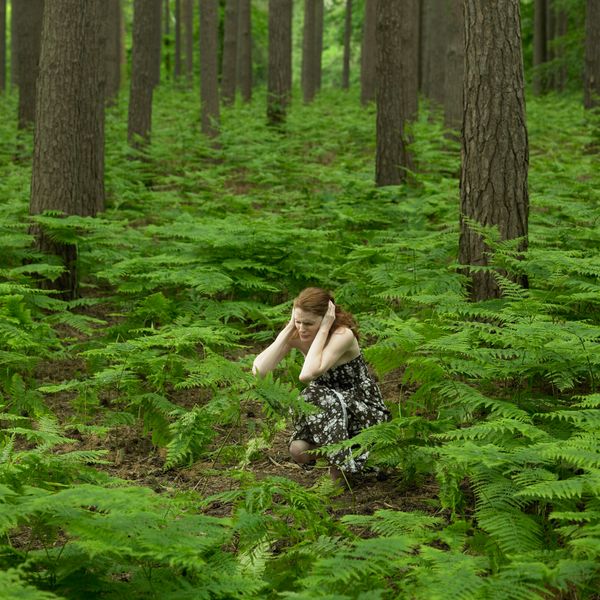 woman in field holding ears