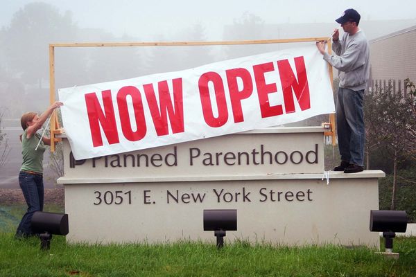 Workers at a Planned Parenthood clinic hang a banner to announce the opening of the facility in Illinois.