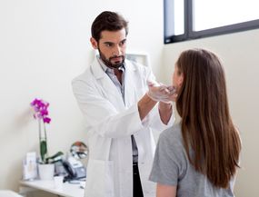 plastic surgeon examining patient