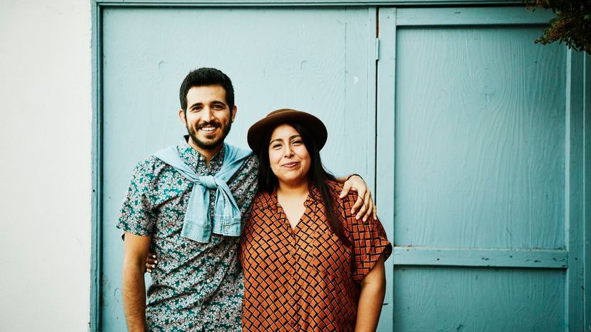 Portrait of embracing couple standing in front of blue wall