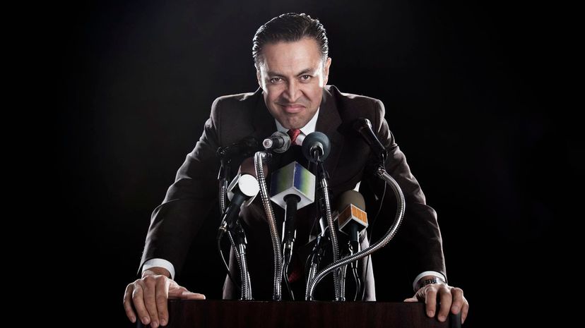 Man standing at podium with microphones