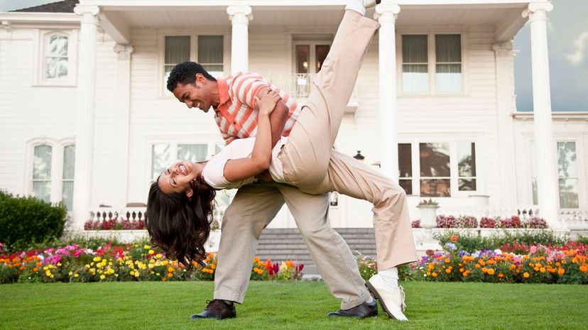 Couple dancing in front of luxury home