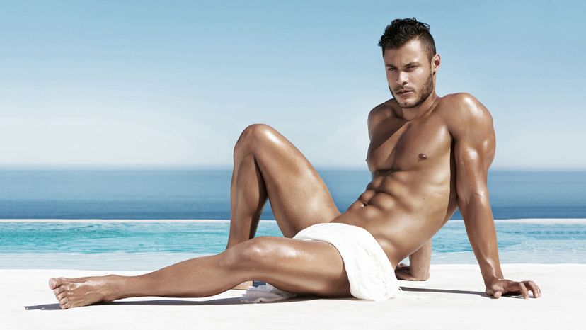 handsome man on beach oiled with towel