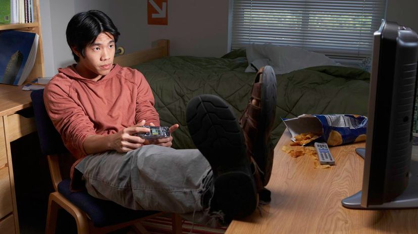 Young man playing video game in dorm room