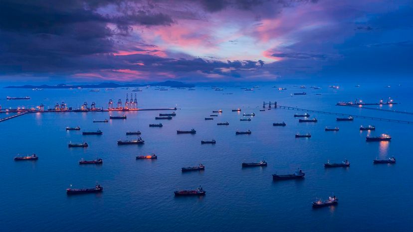 Oil ship tanker park on the sea at dusk with beautiful sky waiting for load/unload oil from refinery for transportation