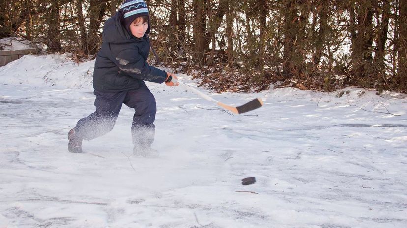 Kid playing hockey in the snow