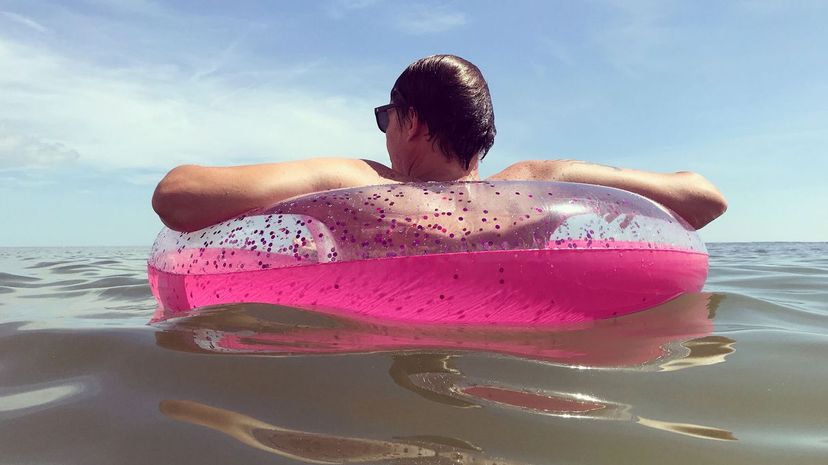 Man Floating in a Pink Inner Tube in the Ocean