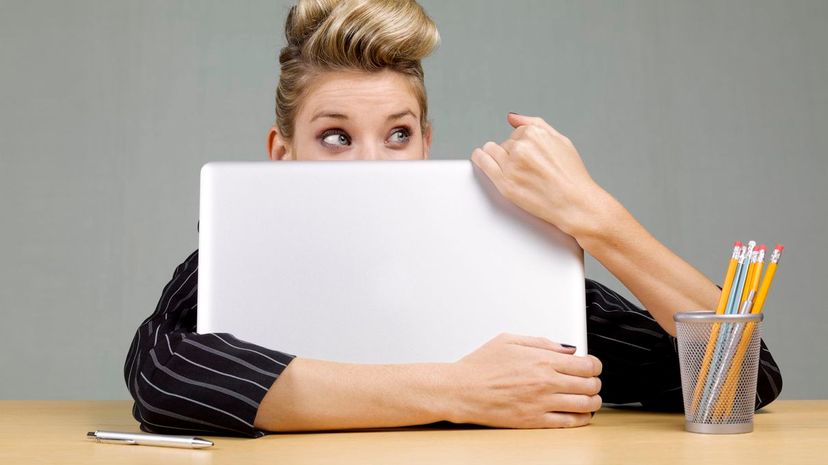 Guilty businesswoman behind laptop