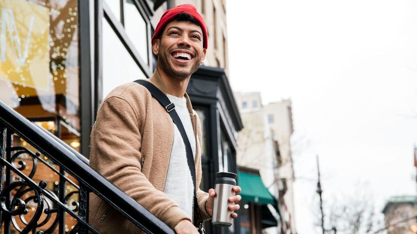 Smiling young man walking down stairs in city