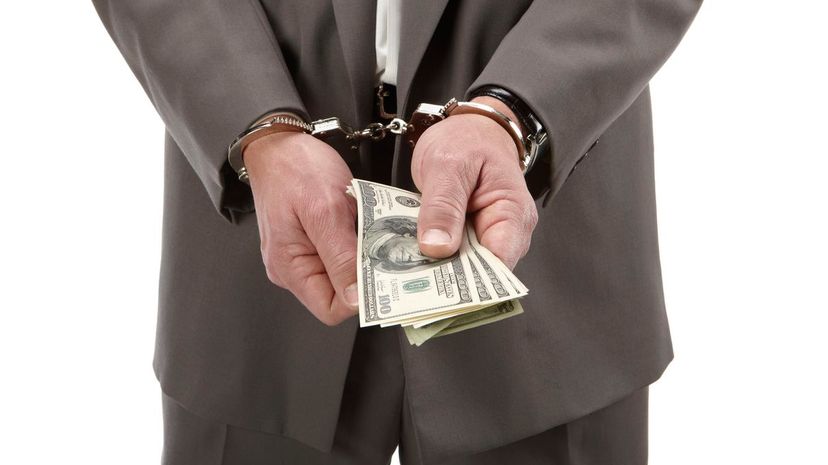 Business man in handcuffs holding money