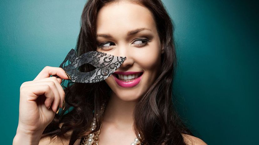 Young woman holding masquerade mask