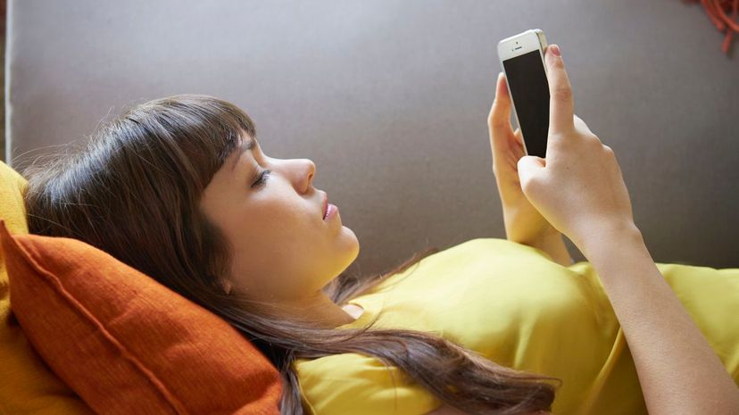 Woman using iphone in bed