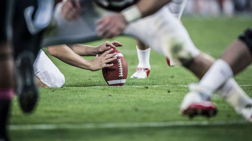 American football players readying to kick ball