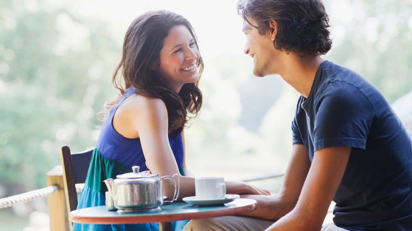 Smiling couple having tea outdoors