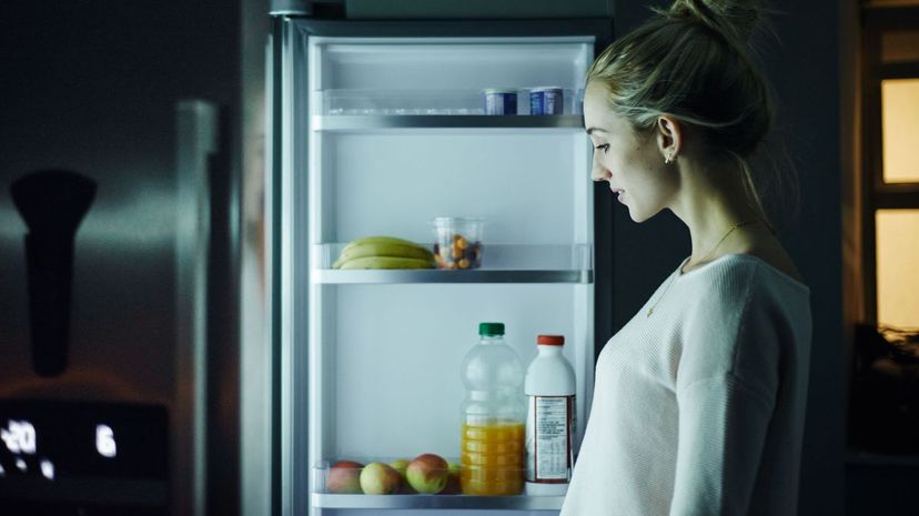 Woman opening the fridge at night