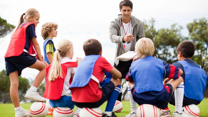 Coach talking to childrens soccer team