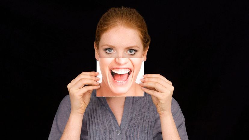 Girl hiding behind mask with happy shouting face