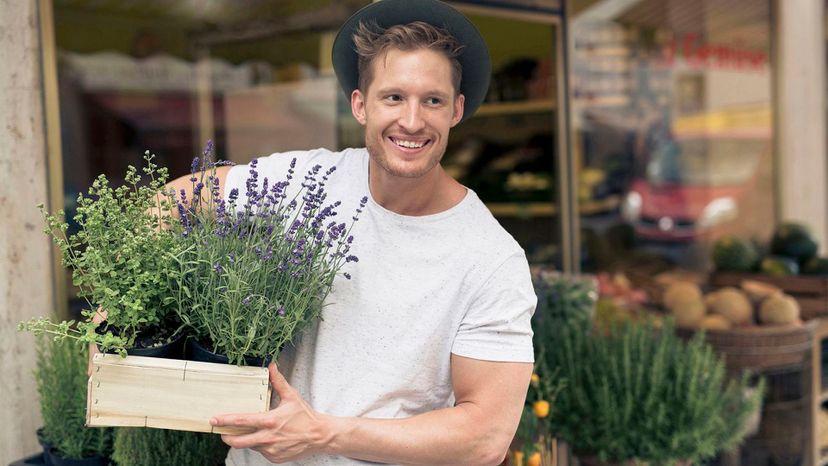 handsome blonde man carrying plants store