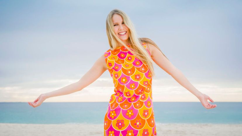 Woman standing with arms outstretched on beach