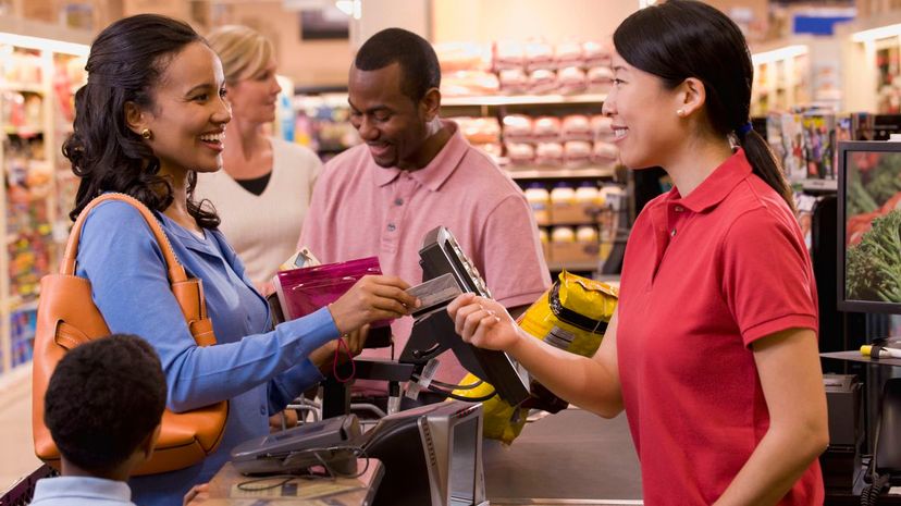 Woman paying with credit card in grocery store