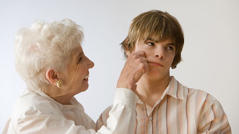 Woman grabbing boy cheek