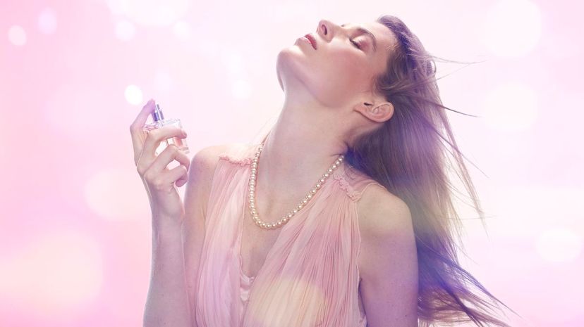 Woman spraying perfume on her neck