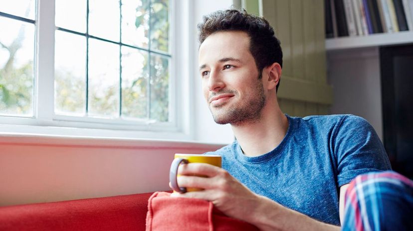 Guy relaxes on sofa looking out of window
