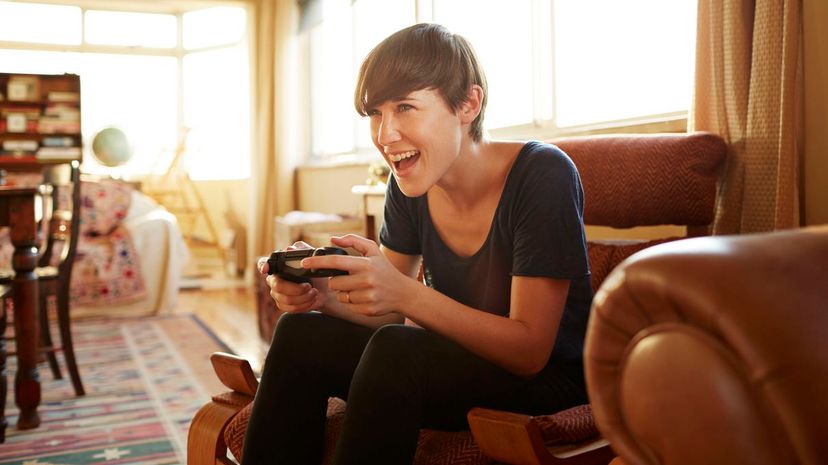 Young woman playing on gaming console at home