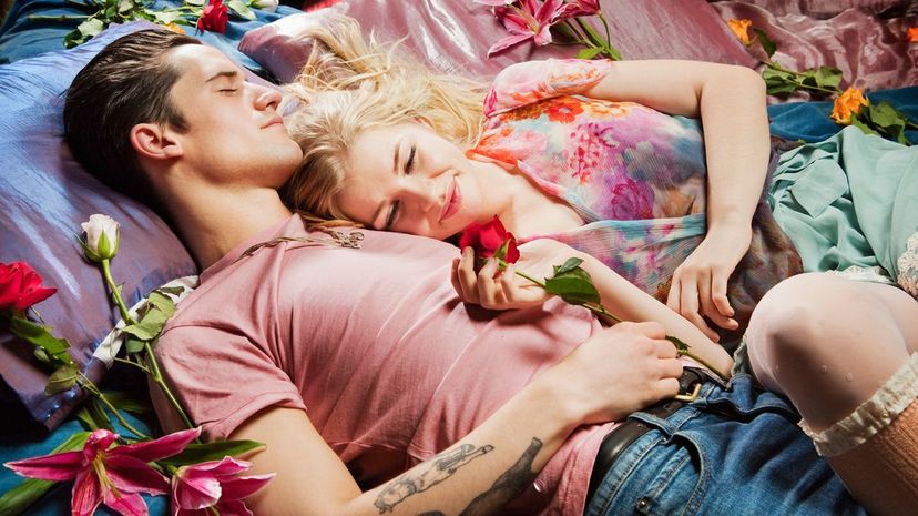 Couple laying on bed with flowers