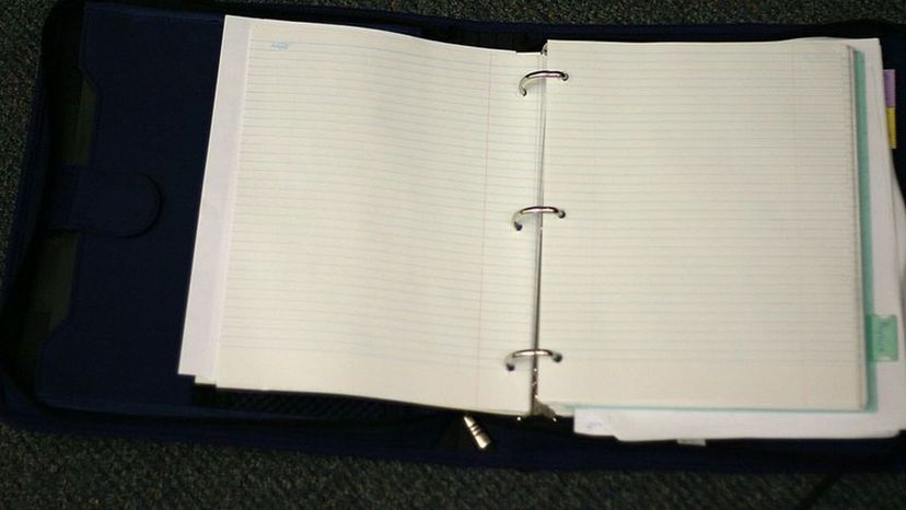 Three ring binder with paper and tabs.