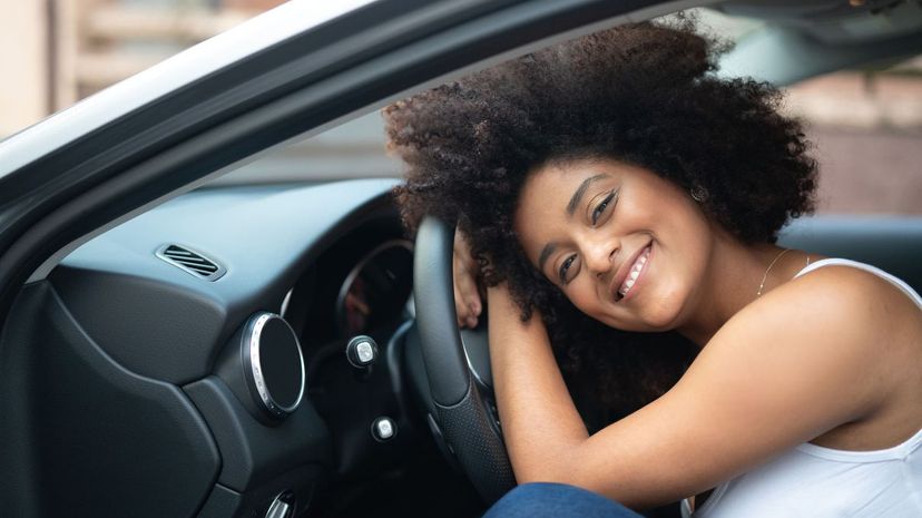 Woman leans on car steering