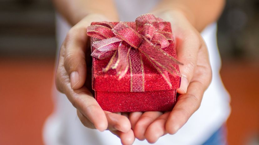 Female hands holding small gift with ribbon