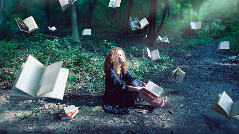 Woman in forest with floating books