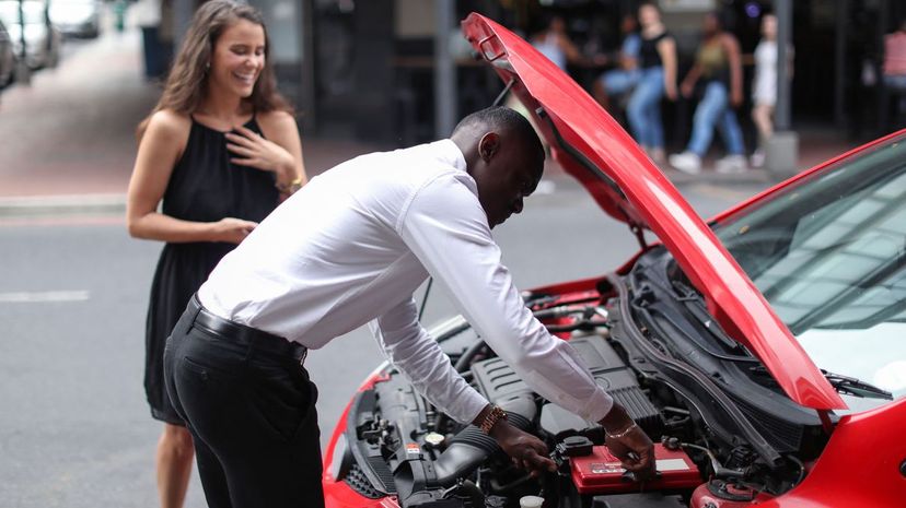 Man helping woman repair car