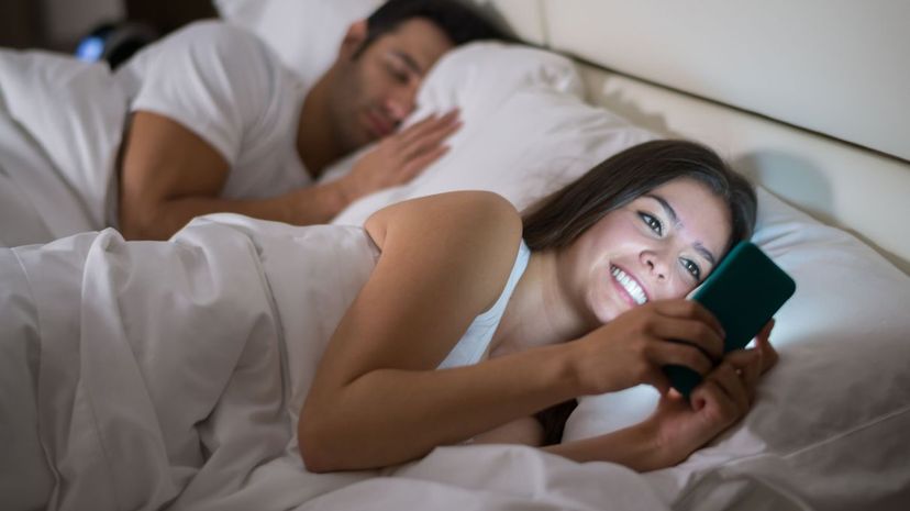 Woman texting in bed