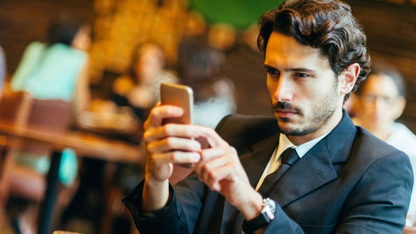 handsome man wavy dark hair looking at phone